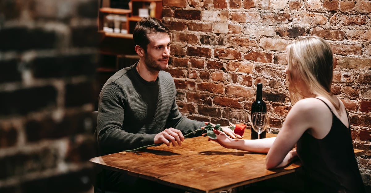 How do you reduce wine when deglazing without burning the fond? - Loving boyfriend giving red rose to girlfriend while sitting near brick wall at wooden table during celebration of event in restaurant