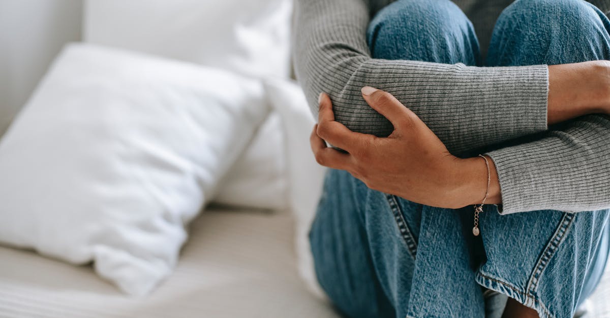 How do you tell if pickles/cucumbers have gone bad - Crop faceless female feeling helpless and frustrated embracing knees while sitting on bed in loneliness