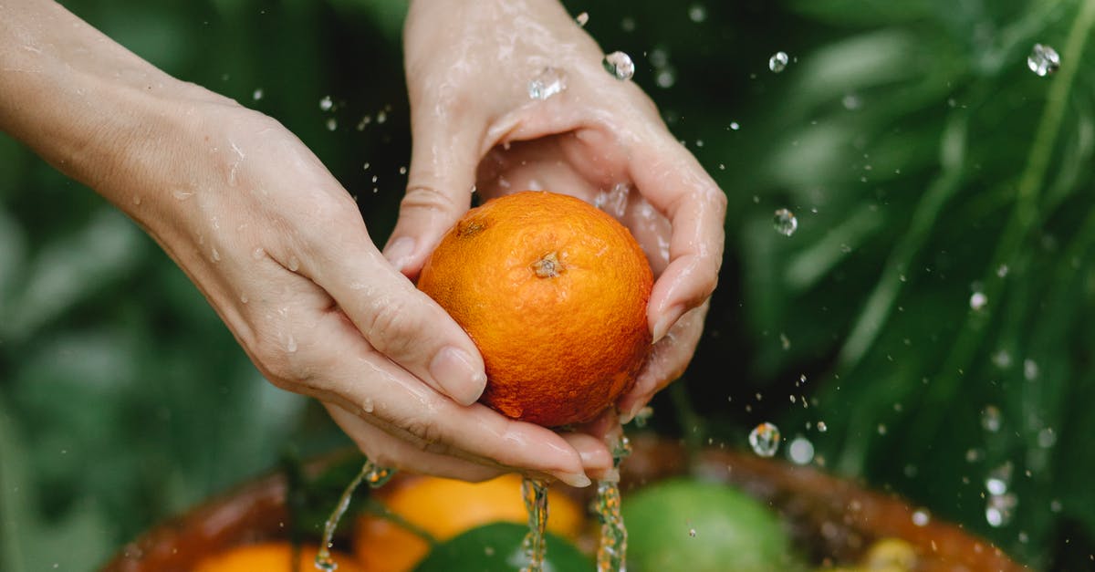 How do you wash fruit and veggies effectively? - Crop woman washing fresh citruses in tropical garden