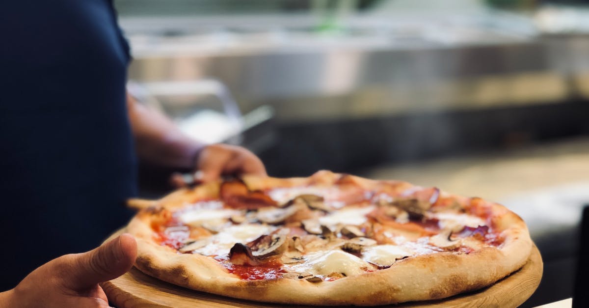 How Does a Hot Water Whipped Pie Crust Work? - Person Holding Whole Pan of Baked Pizza