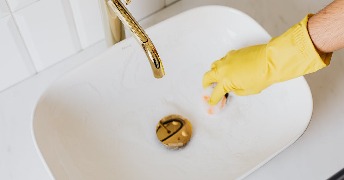 How does a sourdough sponge work? - Person in glove using sponge with detergent for cleaning sink