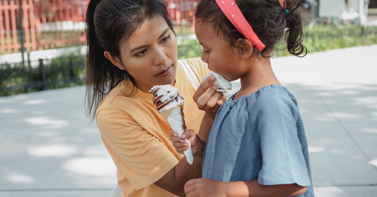 How does buttermilk affect a waffle recipe? - Ethnic caring mother wiping face of adorable crop daughter with sweet tasty ice cream cone