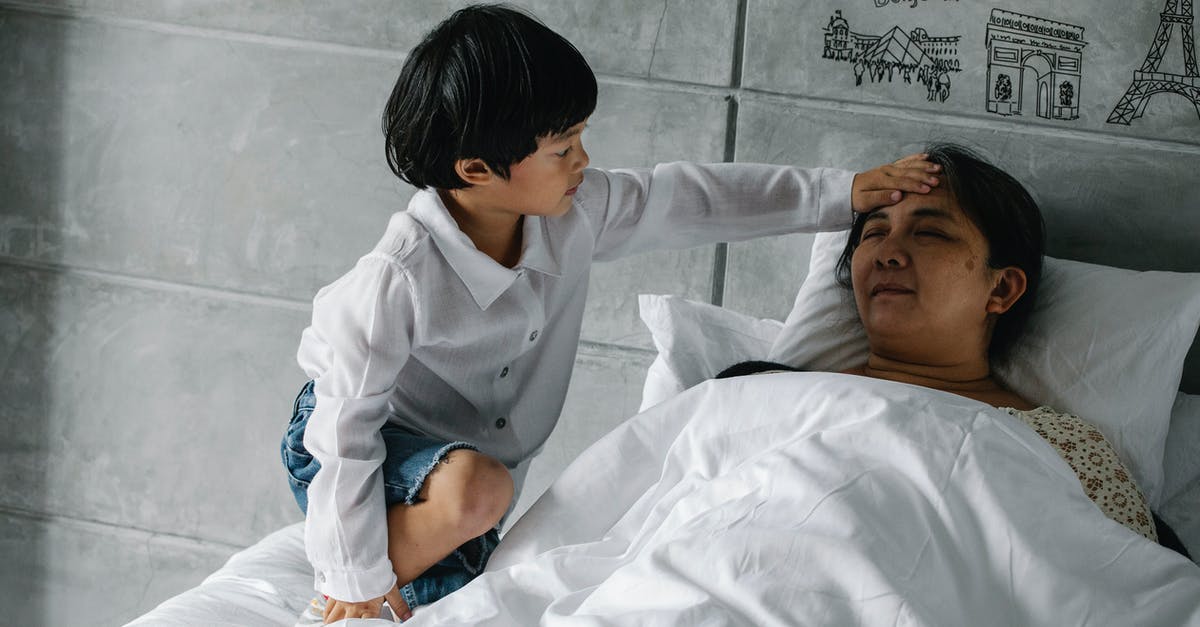 How does core temperature relate with slow cooking? - Little Asian boy measuring temperature of sleeping grandmother