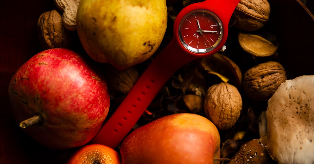 How does harvest time matter with tea? - From above of red rubber wristwatch placed in healthy basket with organic fresh apples pear and orange and composed with different nuts