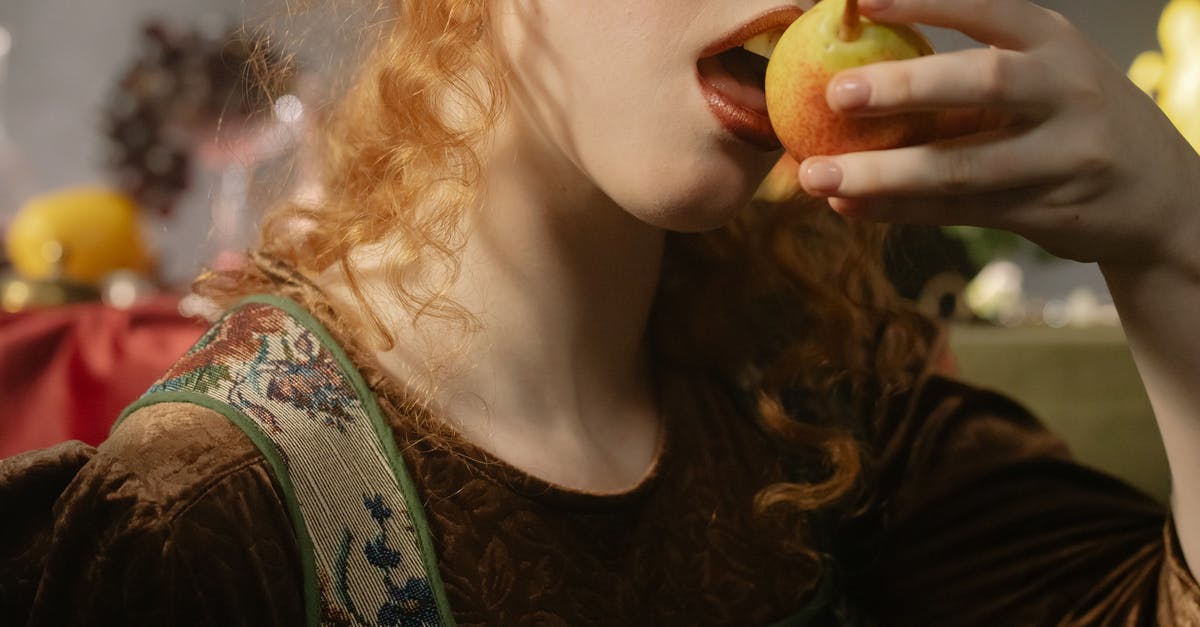 How does liquefying fruit compare to eating them whole? - Woman in Green and White Floral Shirt Holding Apple