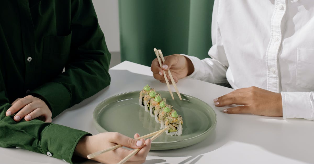 How does one stop sushi seaweed wrapping being too chewy? - People Wearing Long Sleeves Holding Wooden Chopsticks 