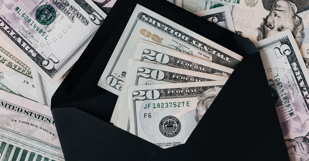 How does produce grading in the US work? - From above of dollar bills in opened black envelope placed on stack of United states cash money as concept of personal income