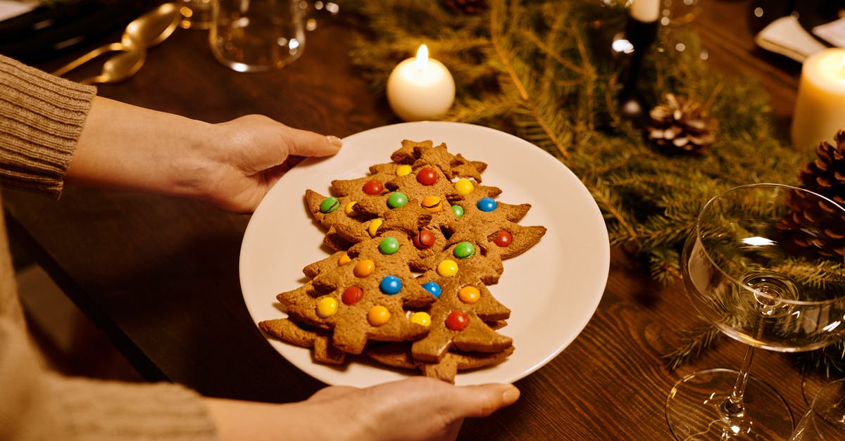How does the baking time change if I scale up a cake recipe? - Person Serving a Platter of Christmas Tree Shaped Cookies