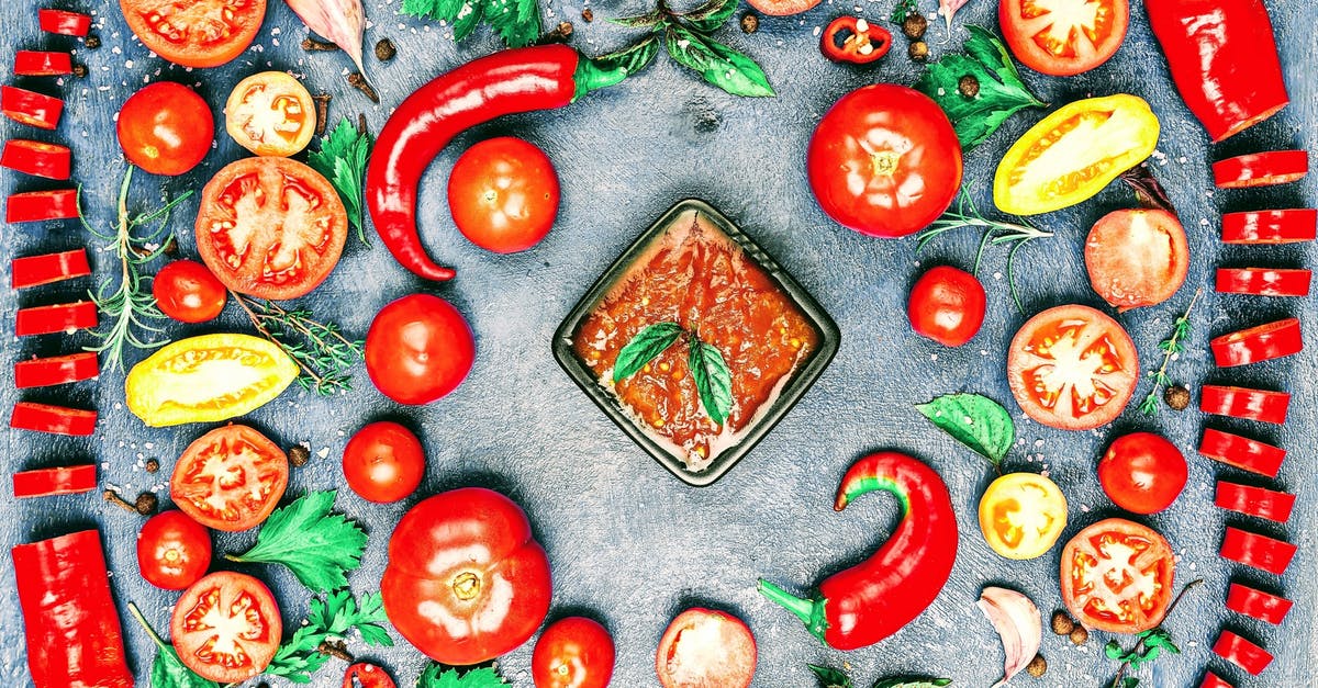 How does the "Suicide Sauce" from Hot Licks rate on the Scoville Scale - Top view of composition of colorful chili pepper and assorted tomato slices near fresh cilantro and parsley leaves with rosemary and thyme sprigs with bowl of savory sauce in center