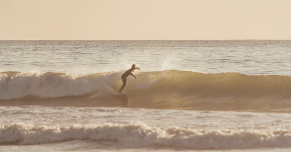 How fast does water cool off after boiling? - Agile surfer riding rough wave on cloudy day