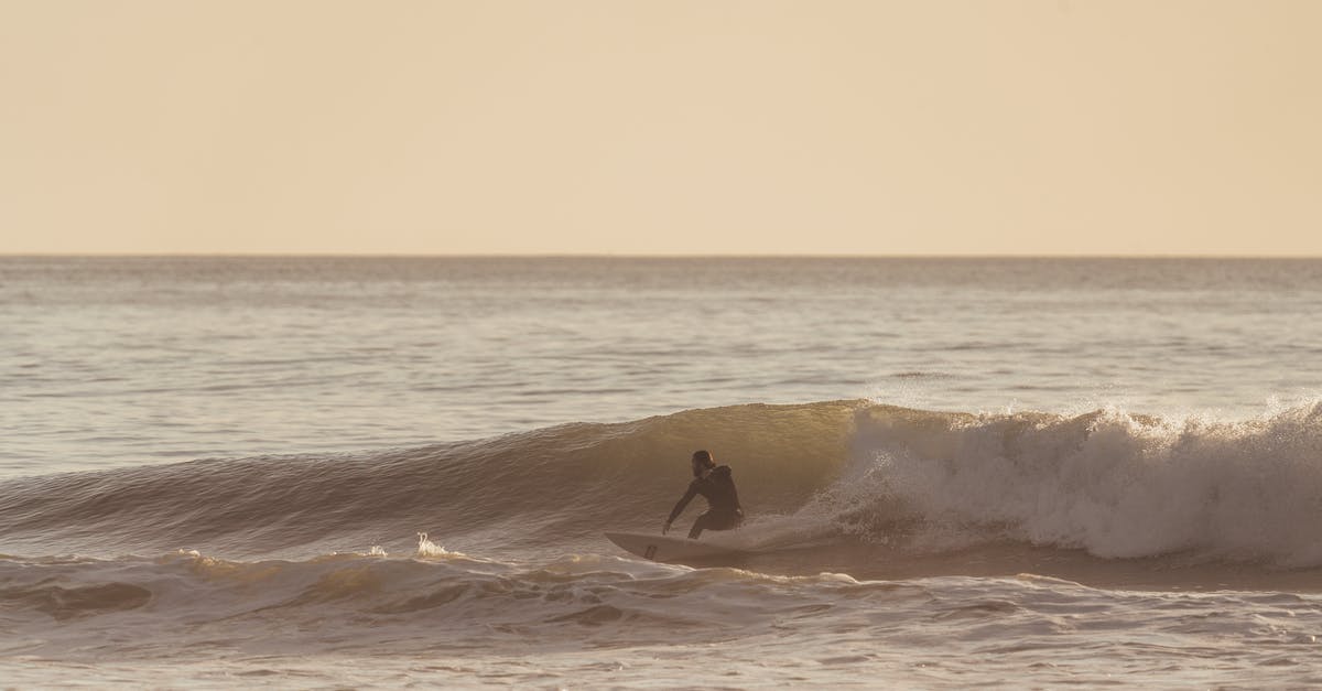 How fast does water cool off after boiling? - Man riding wave on surfboard under cloudy sky