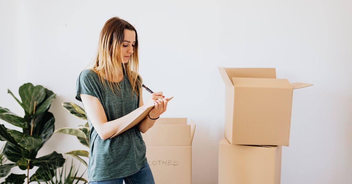 How important is RPM in a blender? - Focused young lady in casual wear taking notes in clipboard while standing near packed carton boxes before moving into new house