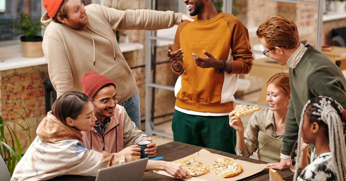 How is one supposed to properly eat multi-level hamburgers? - Multiracial Group of People by the Table