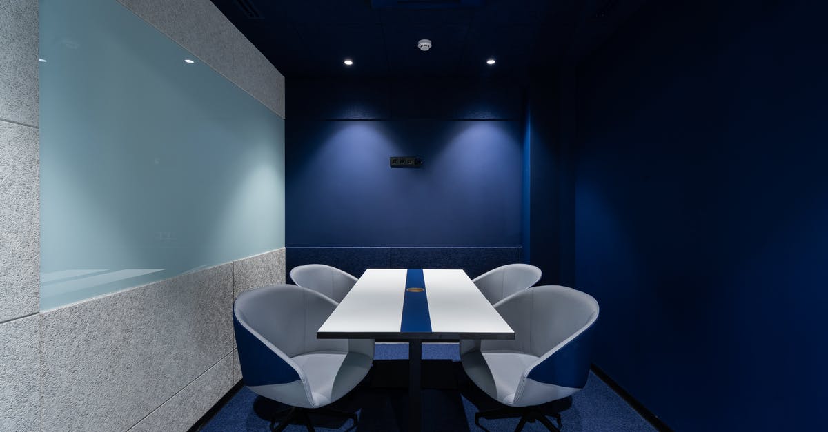 How long before steak is at room temperature? - Comfortable chairs placed on carpet at long white desk in modern conference room with blue walls in contemporary business center