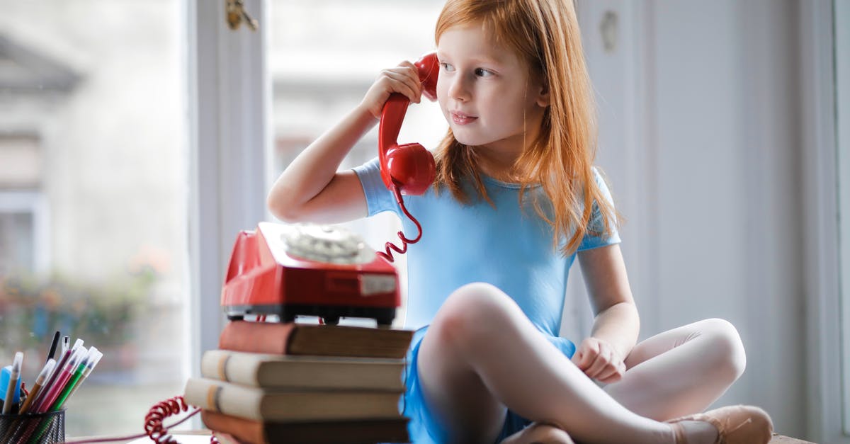 How long can i keep home made caesar dressing? - Low angle of calm redhead preteen lady in blue dress and beige sandals looking away and having phone call using retro disk telephone on stack of books while sitting with legs crossed on wooden table against window at home