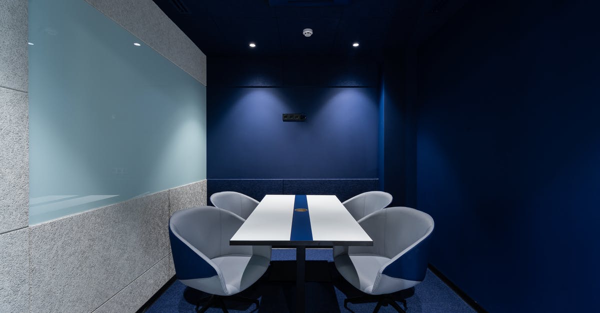 How long can I keep unleavened dough at room temperature? - Comfortable chairs placed on carpet at long white desk in modern conference room with blue walls in contemporary business center