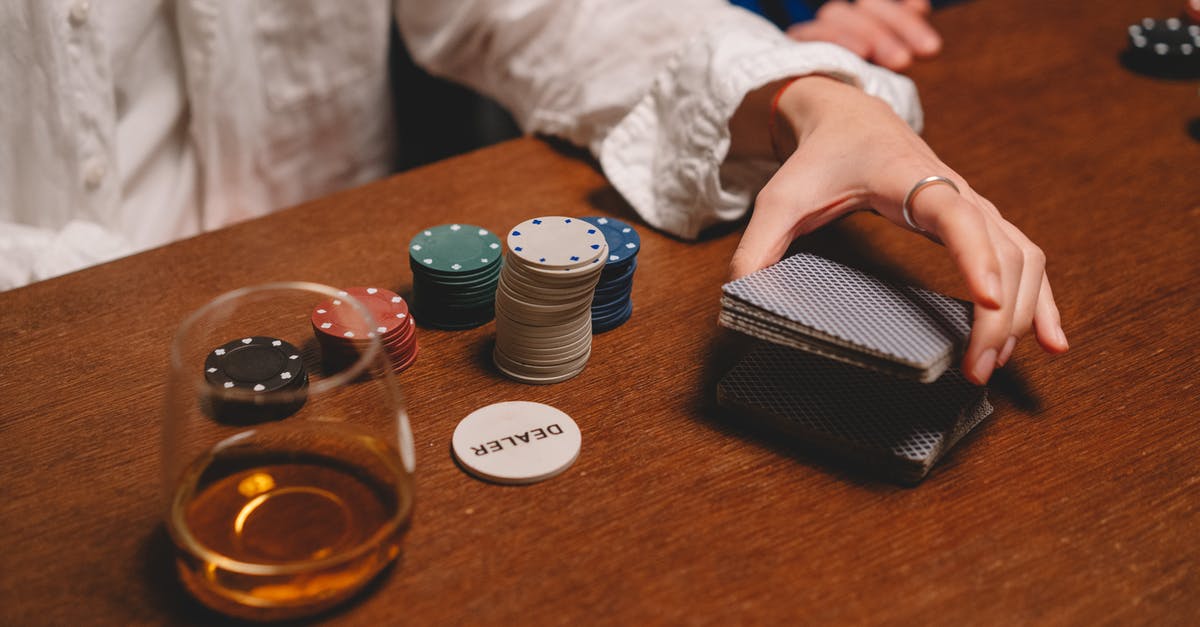 How long can you keep whiskey in the freezer? [duplicate] - Person Wearing White Long Sleeve Shuffling the Cards