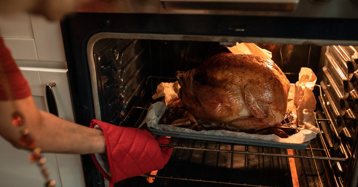 How long do I pre-heat a whole chicken for on the stove before placing it in the oven to roast? - Person Holding a Raw Meat