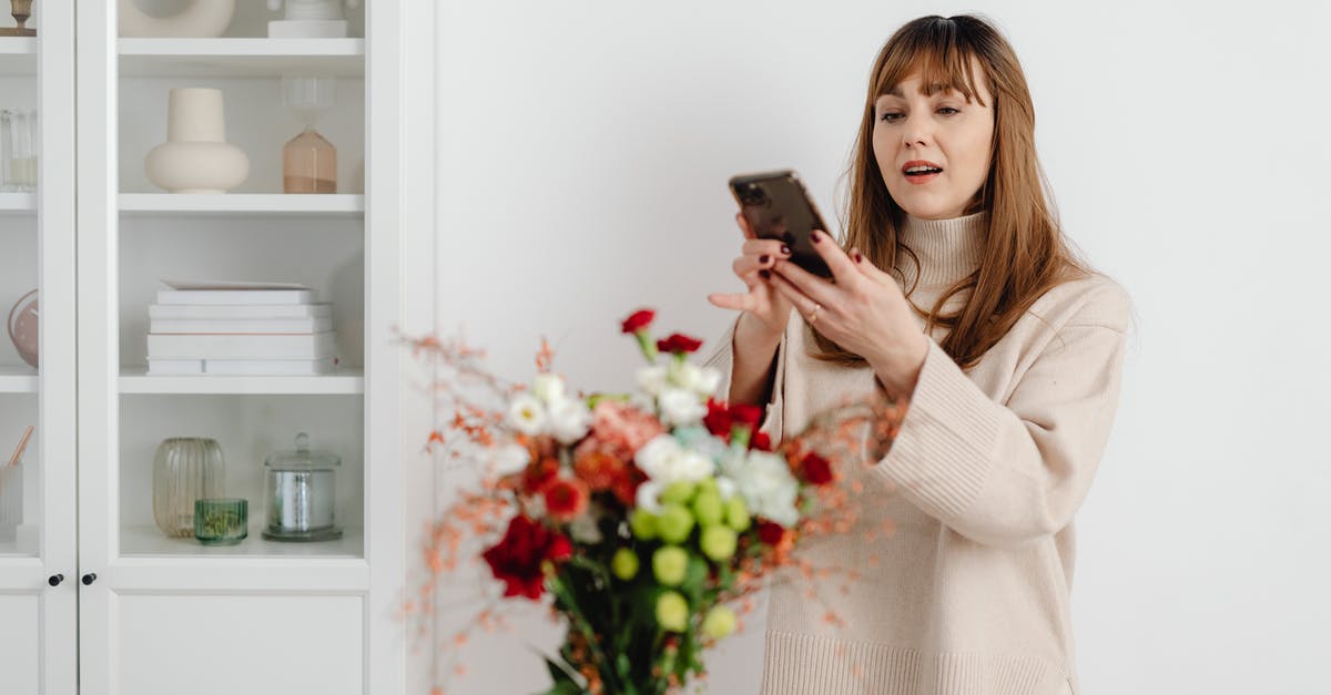 How long does it take for buttermilk to go bad? - Woman in Beige Sweater Taking a Photo of Flowers