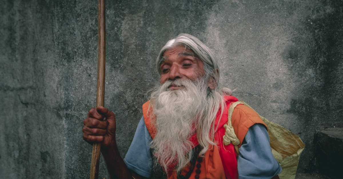 How long does it take to ripen tomatoes in a bag with bananas? - Poor senior Indian man with gray beard against rough wall