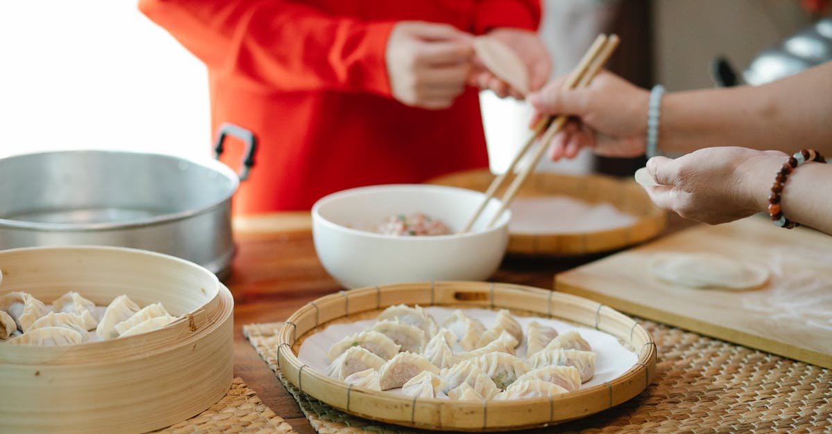 How long does raw ground meat last in the fridge? - Crop woman with relative filling dim sum in kitchen