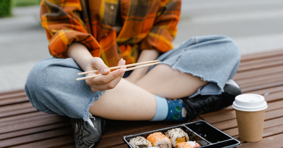 How long in fridge for sushi steaks? - Person Sitting on a Wooden Floor Eating Sushi