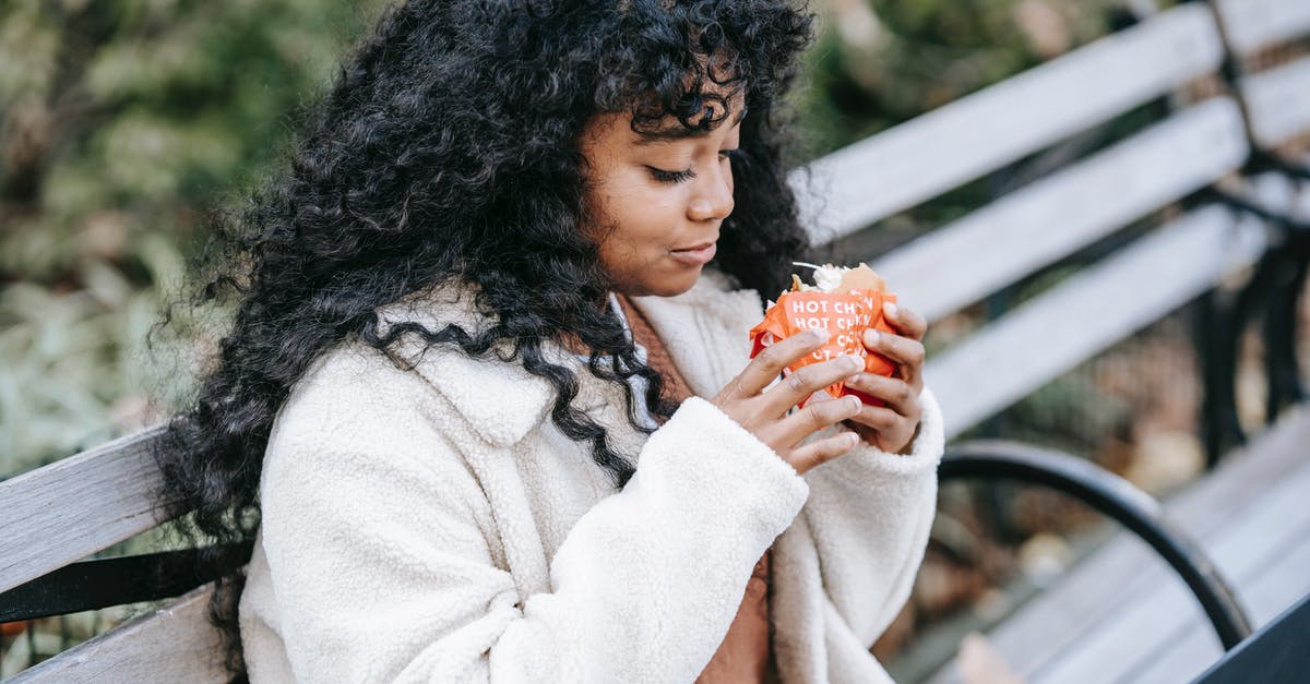 How long is cooked hamburger able to sit in a crockpot? - Content black woman eating tasty burger on park bench
