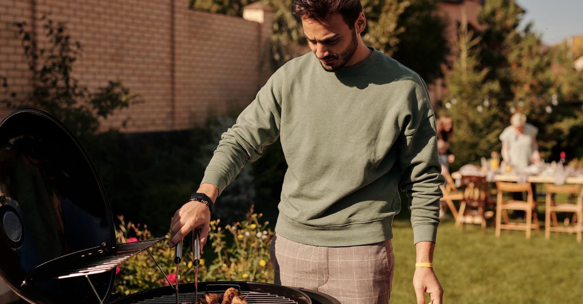 How long should it take to bbq half a chicken? - Close-Up Shot of a Man Grilling Chicken