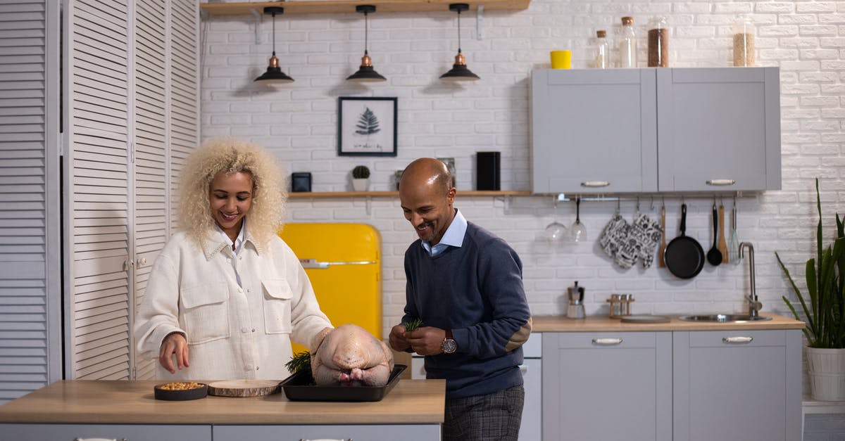 How long to cook stuffed turkey - Positive black couple preparing turkey in kitchen