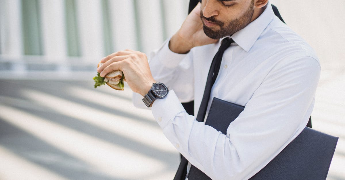 How long will a peanut butter sandwich last? - 
A Bearded Man in a Corporate Attire Looking at His Watch while Holding a Sandwich