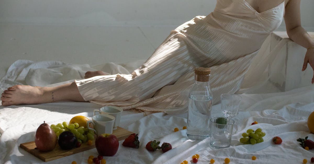 How long would fruit in a water bottle last? - Woman resting near glassware and sweet fruits on wooden board