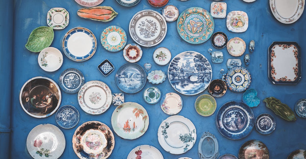 How many ceramic knives do I want? - Composition of various decorative ornamental plates of different sizes and colors arranged on blue wall