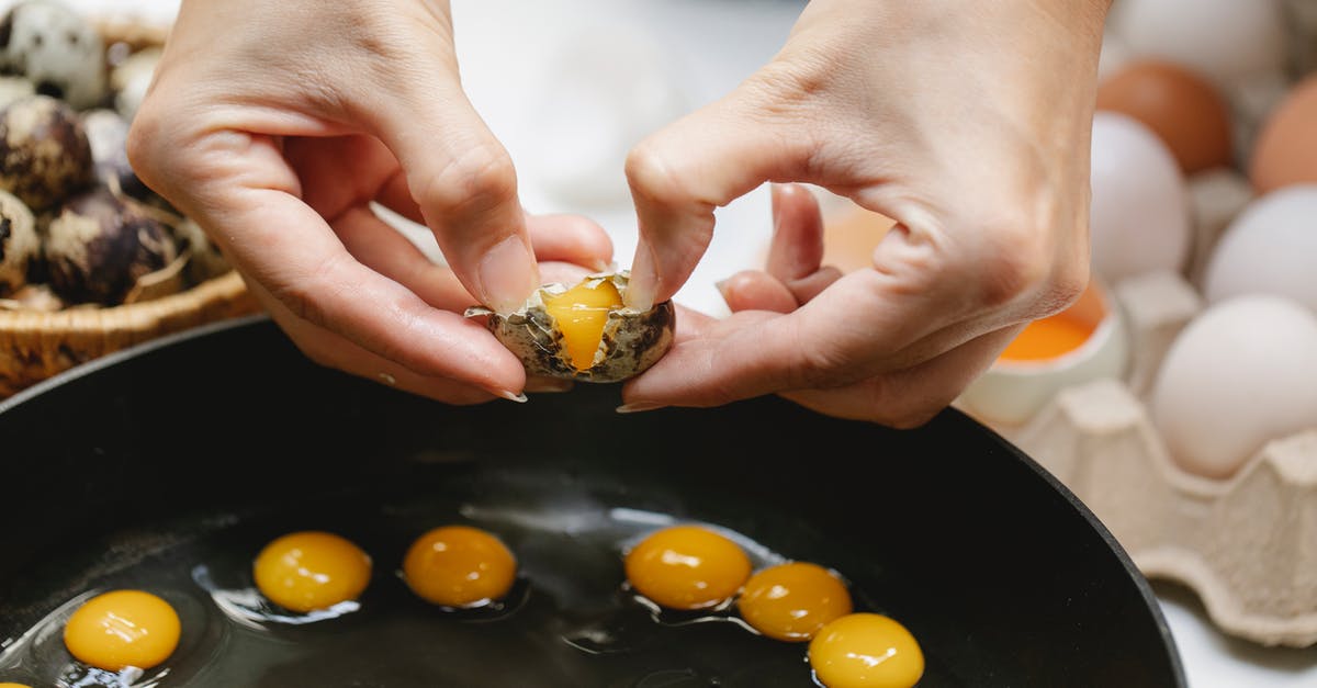 how many grams of butter can be absorbed by 5 egg yolks? - Crop woman breaking quail egg into pan