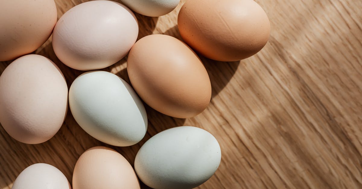 How many times can you reheat boiled eggs? - Top view of assorted mixed chicken raw multicolored eggs placed together on wooden surface during daytime