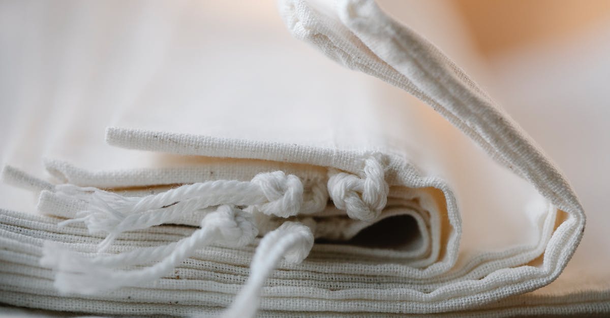 How many times can you reuse bones to make broth? - Pile of folded white cotton bags with ropes made of ecological cloth placed on table in light room on blurred background