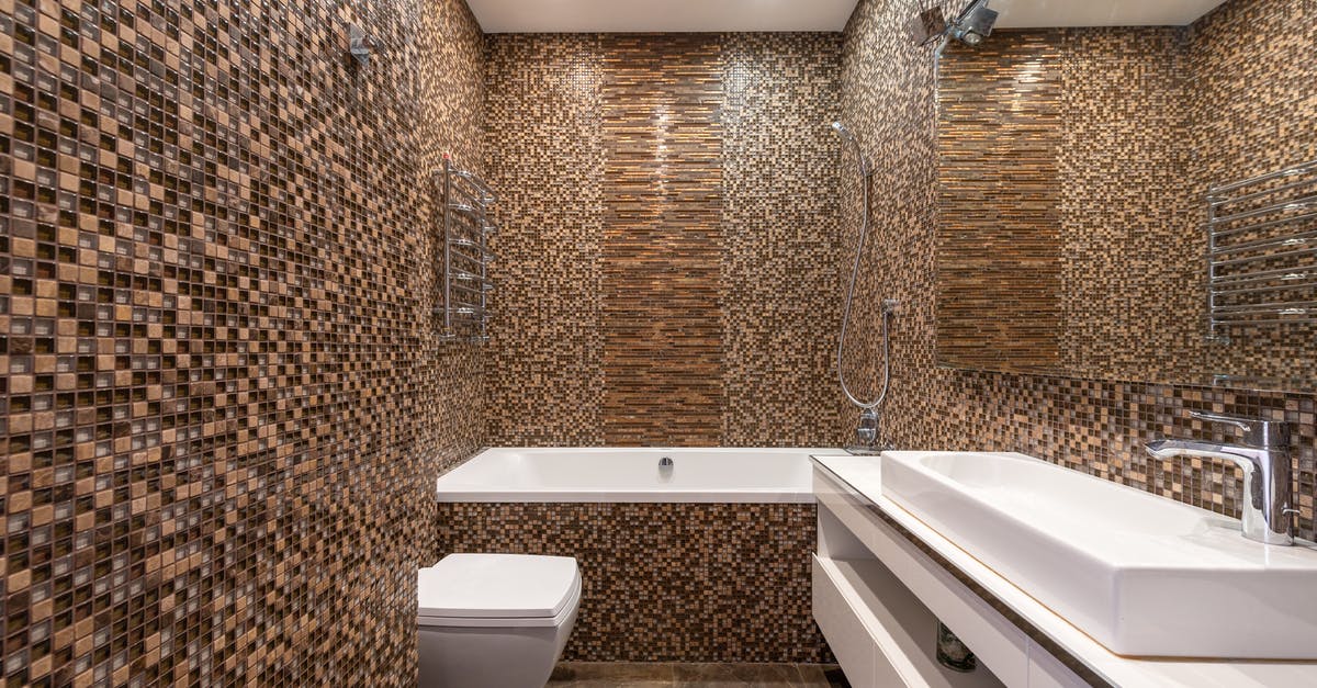 How many wash cycles should I aim for when washing brown rice? - Mosaic tiled walls in modern bathroom with ceramic sink on white cabinet and bathtub