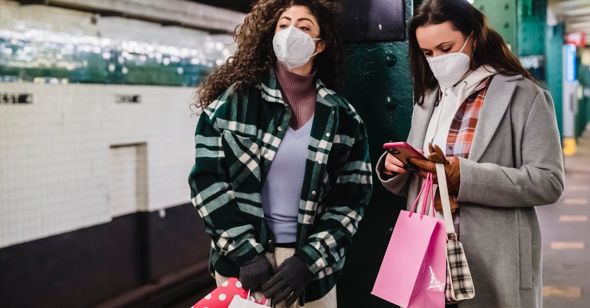 How much citric acid is safe to use? - Female in protective mask using mobile phone while waiting for train on platform of subway station with friend standing with gift bags