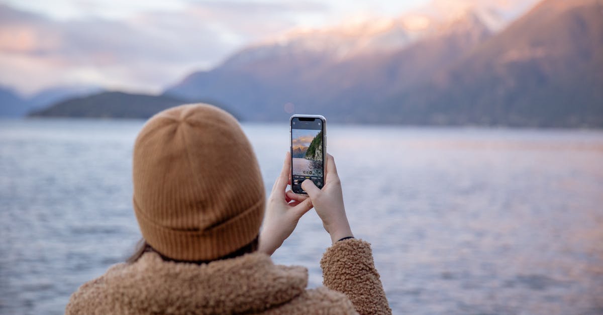 How much CO2 does it take to carbonate water using a household Soda Siphon? - Unrecognizable female traveler taking photo of lake and mountains