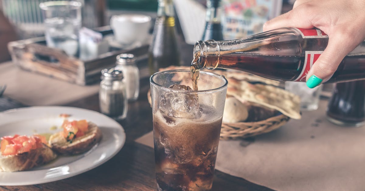 How much fizz in water carbonated with ISI whipper? - Photo of Cola Pouring Into a Glass with Ice Cubes