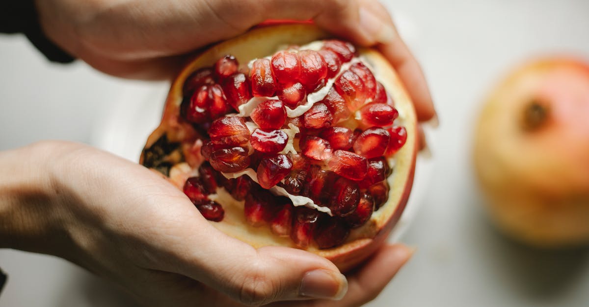 How much is in a handful of spinach? - Fresh pomegranate in hands of woman