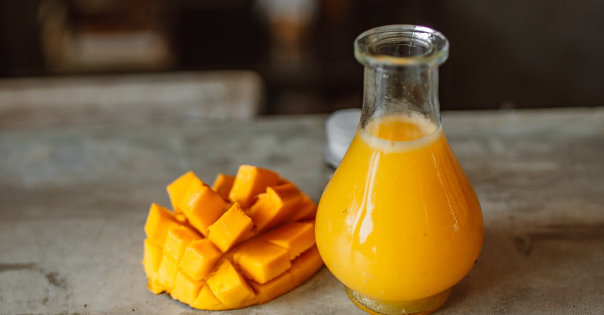 How much juice can a mango yield if run through a juicer? - Sliced Mango Beside a Clear Glass Bottle With Yellow Liquid 