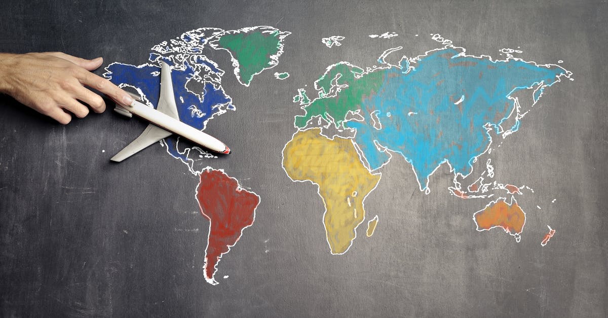 How much prime rib should I plan per person? - Top view of crop anonymous person holding toy airplane on colorful world map drawn on chalkboard