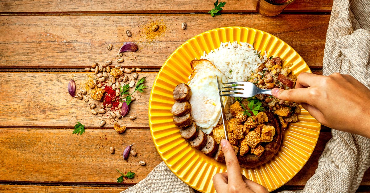 How much rice should I cook per person? - Crop person eating appetizing rice with fried egg and sausage