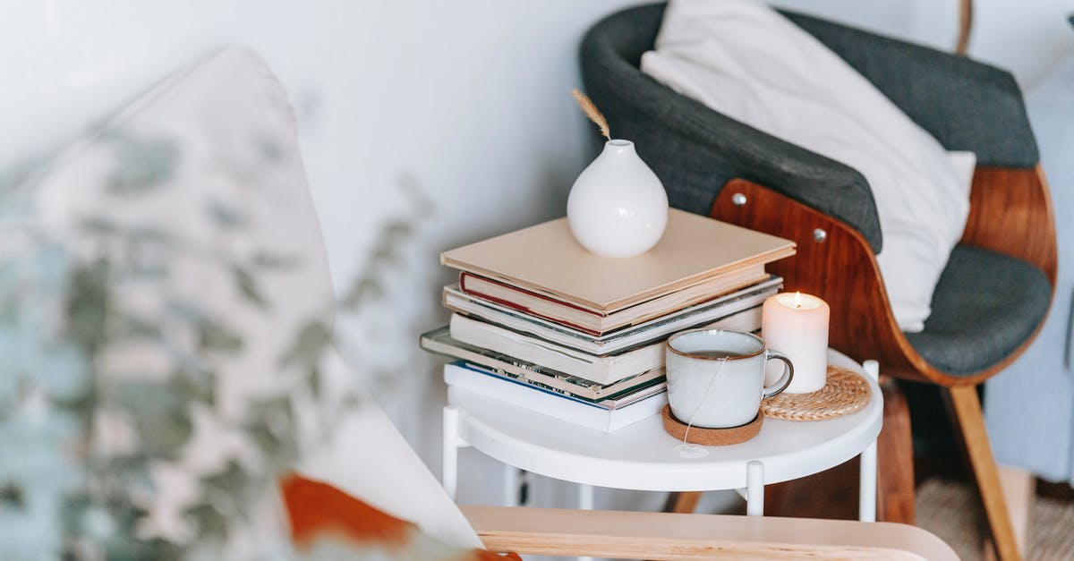 How much tea is ideal out of one tea bag? - Cup of tea and burning candle against books at home