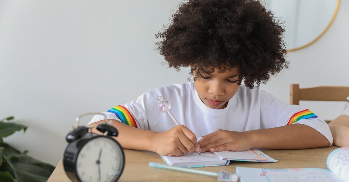 How much time does it take to boil salmon? - Concentrated African American child writing in notebook while studying at desk with alarm clock at home