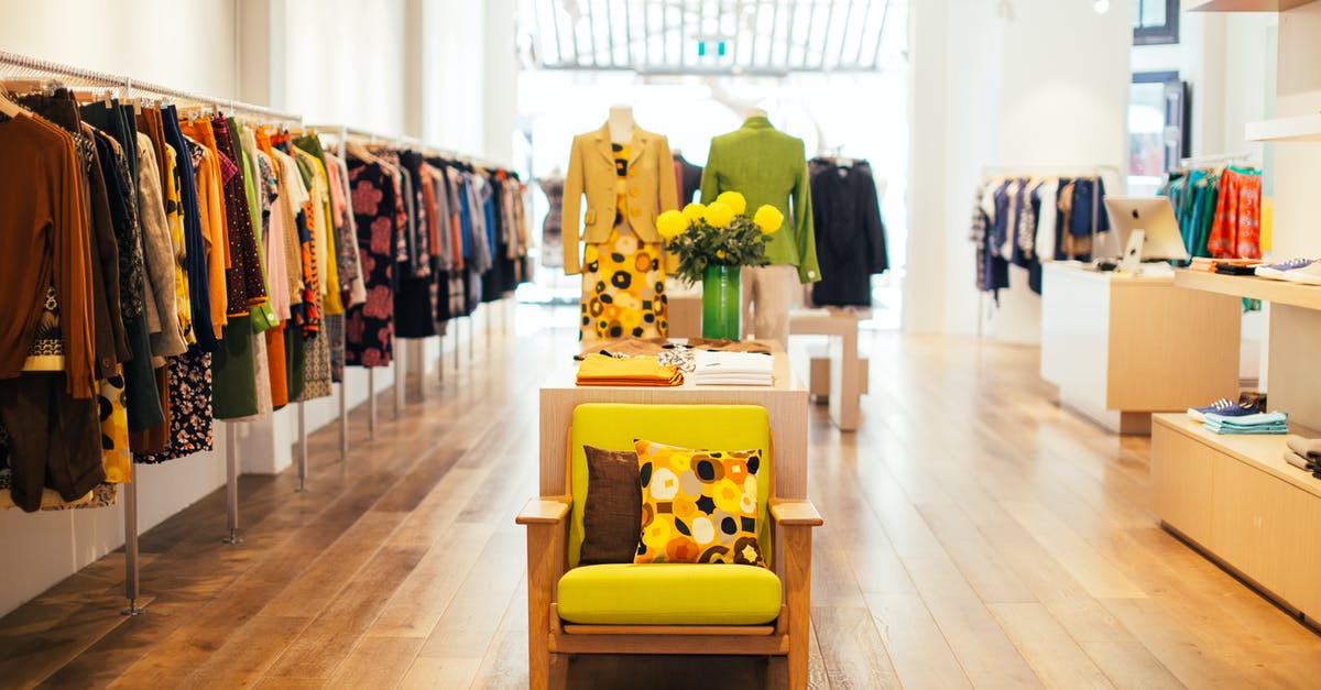 How should I choose corn? - Interior of modern fashion store with stylish colorful clothes handing on rack in daytime