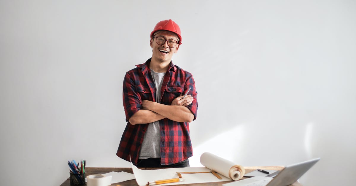 How should I improve my chopping flow? - Smiling casual man in hardhat and glasses holding arms crossed looking at camera while standing at desk with paper draft and stationery