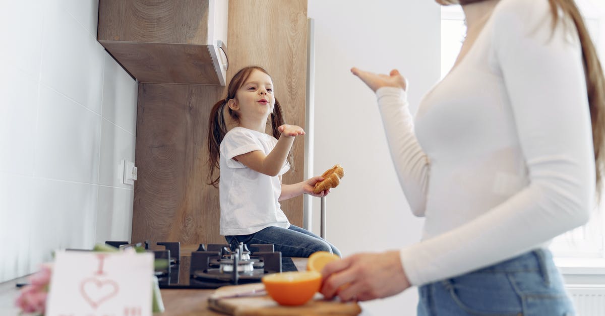 How should I prepare Risotto - Loving mother and daughter blowing kiss on kitchen