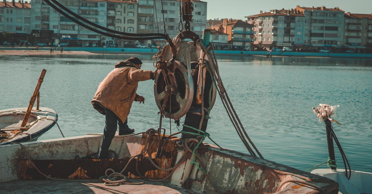 How should I roast bay nuts? - Man in Brown Jacket and Black Pants Standing on Boat