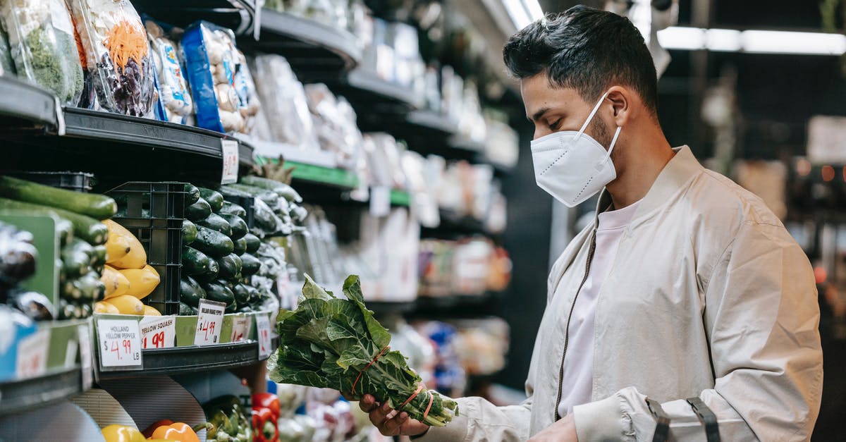 How should I store herb butter? - Young ethnic guy buying bunch of fresh spinach in supermarket